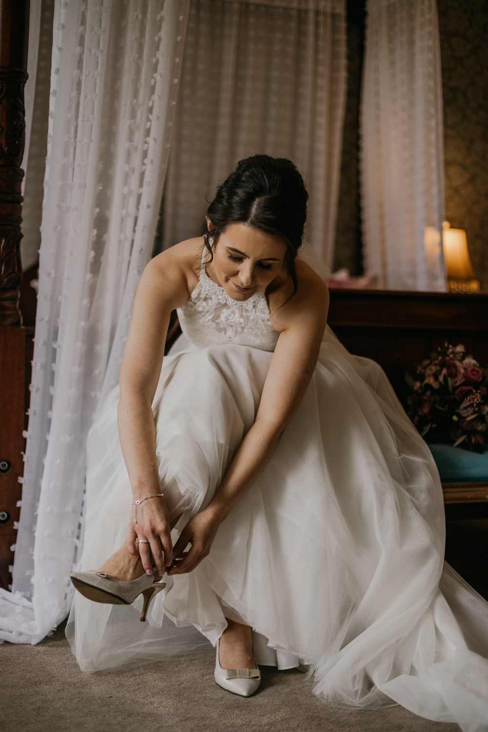 bride getting ready the morning of of her wedding timing her shoes